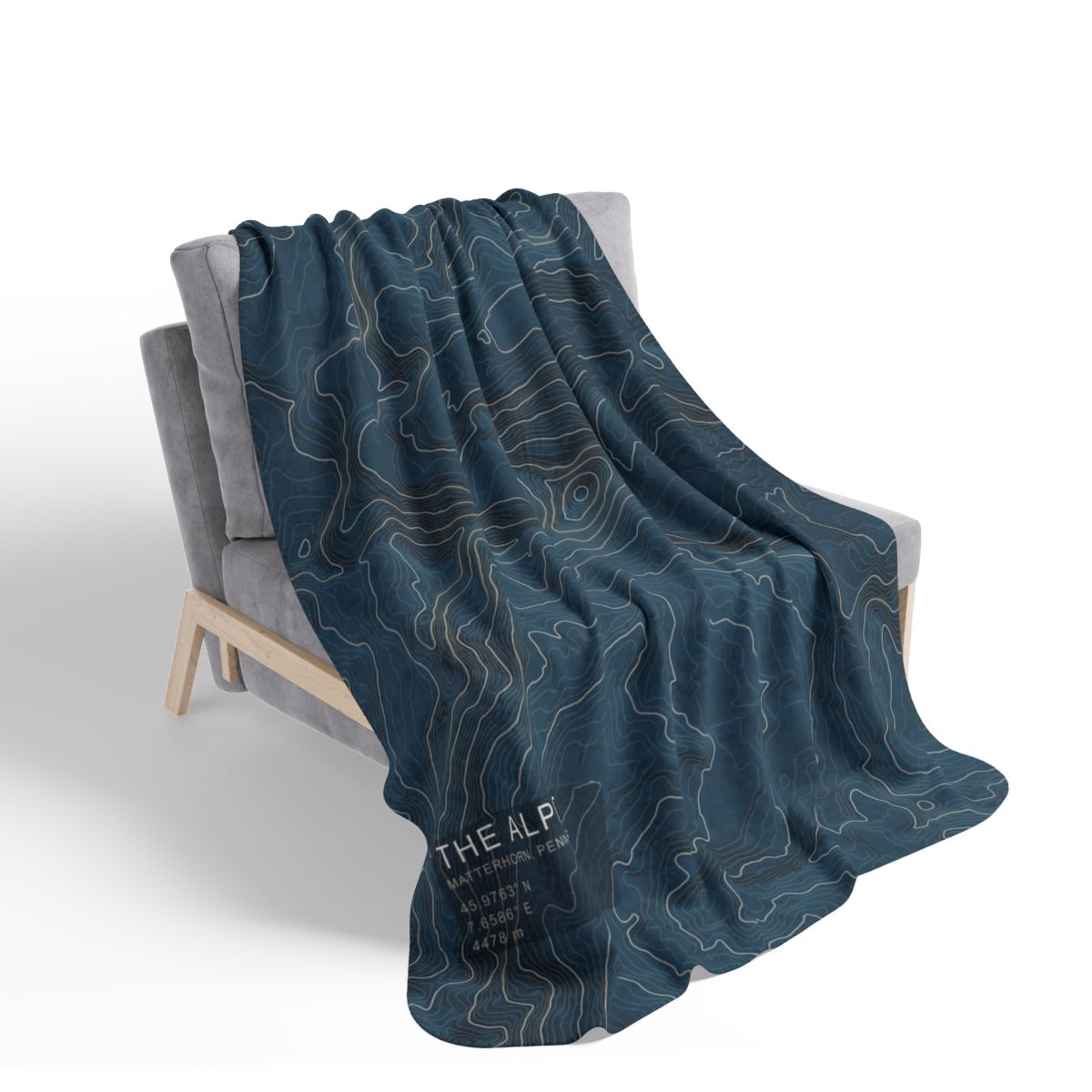 The Alpine blanket draped over a chair with gray fleece reverse visible