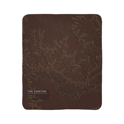 The Canyon Grand Canyon topographic fleece blanket shown flat in dark rust