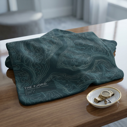 The Fjord topographic fleece blanket spread on a wooden table